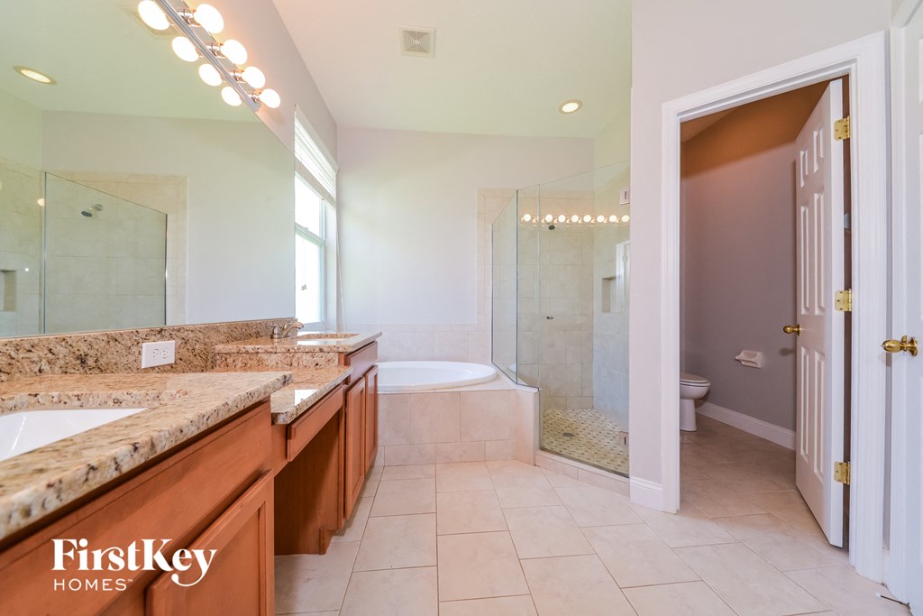 A bathroom with a marble countertop and a walk-in shower.