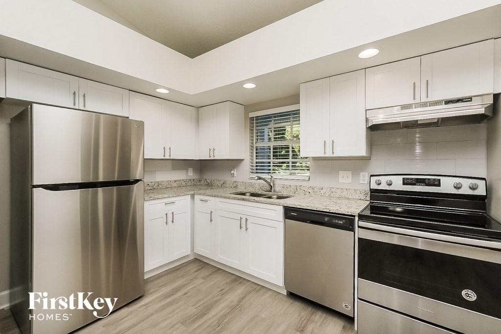 a kitchen with white cabinets and stainless steel appliances