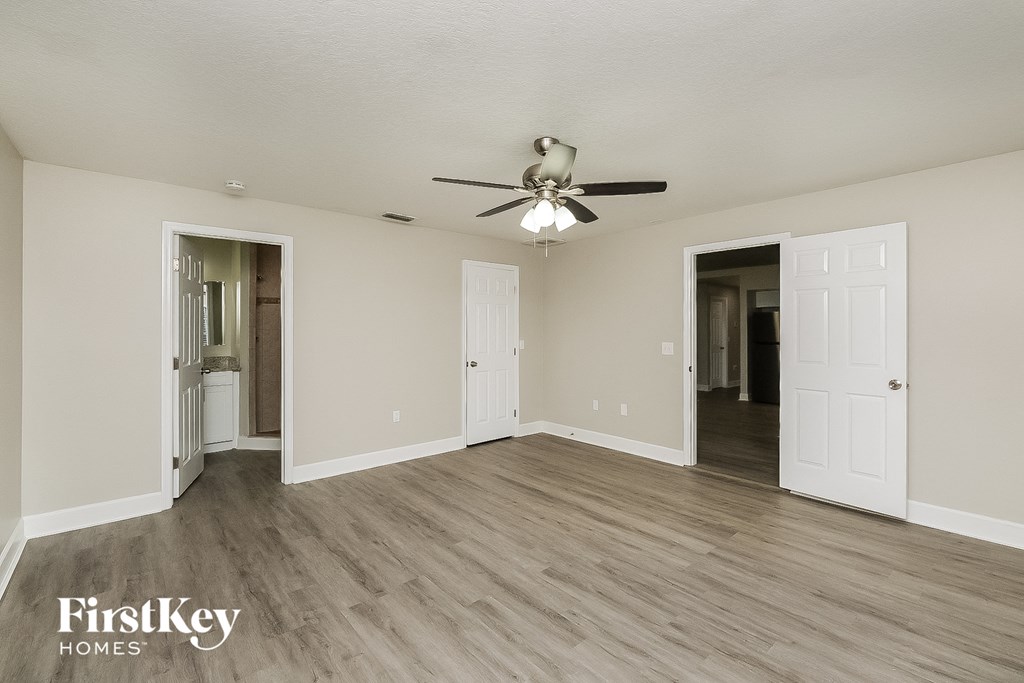 the living room of an empty house with a ceiling fan