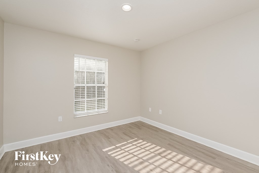 a spacious living room with hardwood flooring and a window