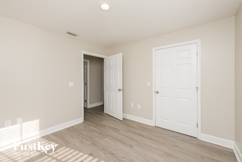 a bedroom with two doors and a door to a closet