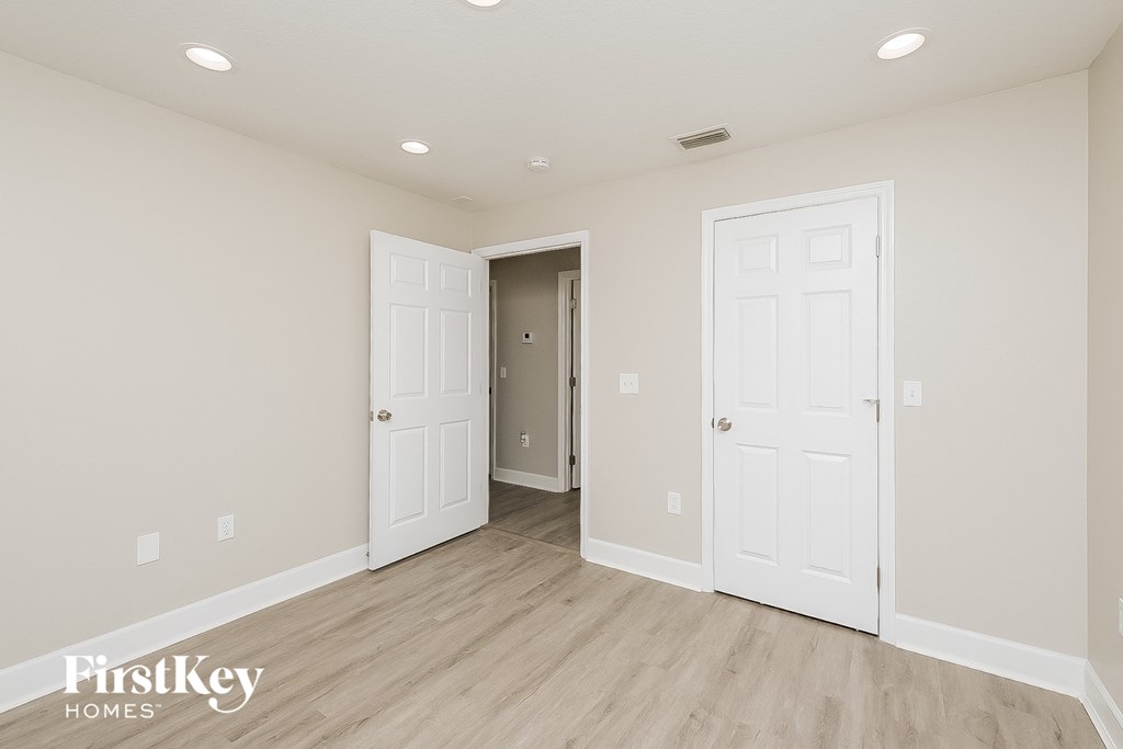 the living room of a new home with white doors and wood flooring