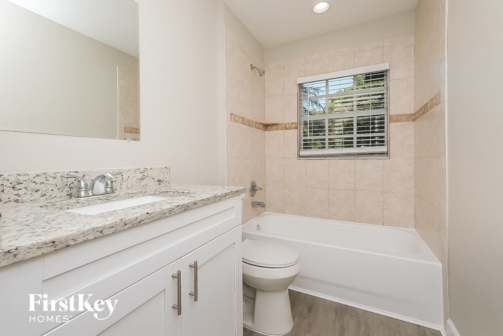 a bathroom with a toilet and a tub and a sink