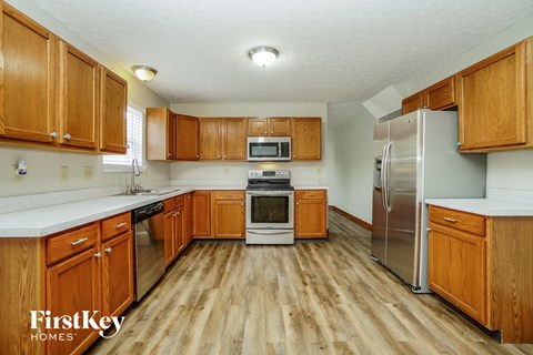 A kitchen with wooden cabinets and a refrigerator.