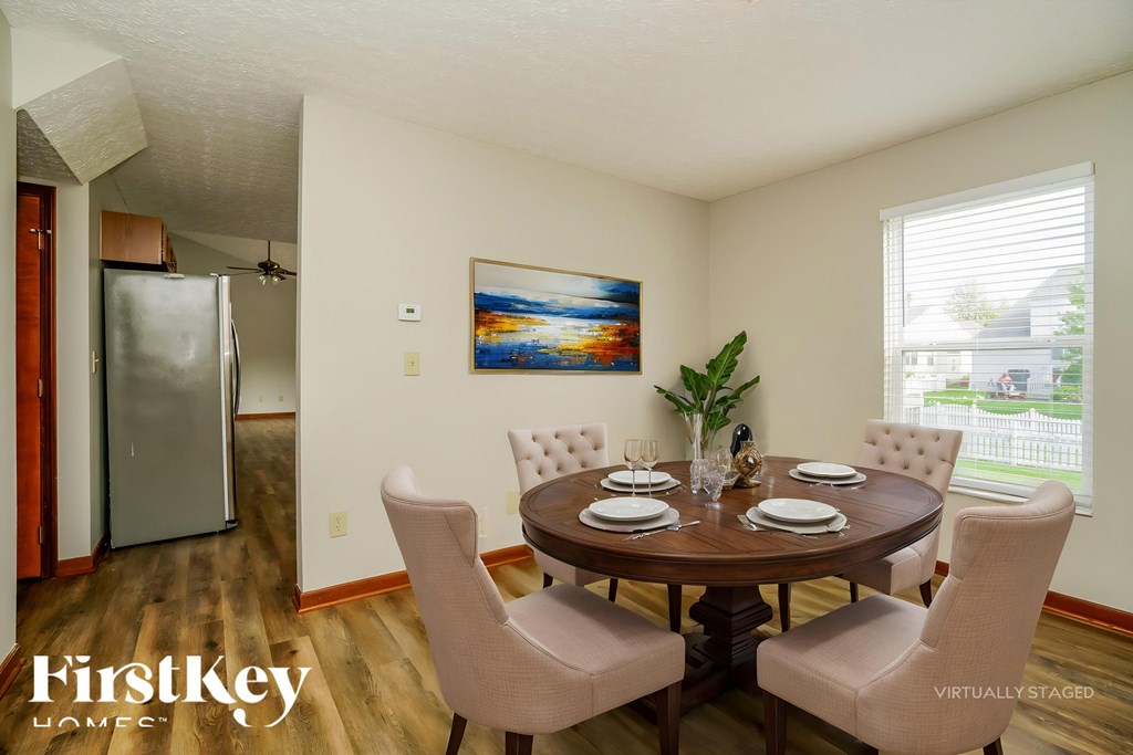 A dining room with a wooden table and chairs.