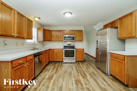 A kitchen with wooden cabinets and a refrigerator.