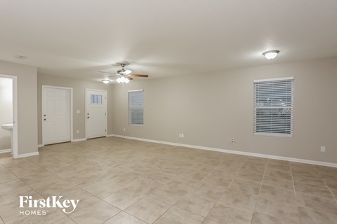 A spacious room with a ceiling fan and tiled flooring.