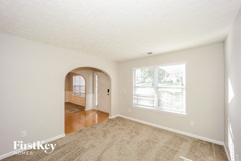 a living room with carpet and a large window
