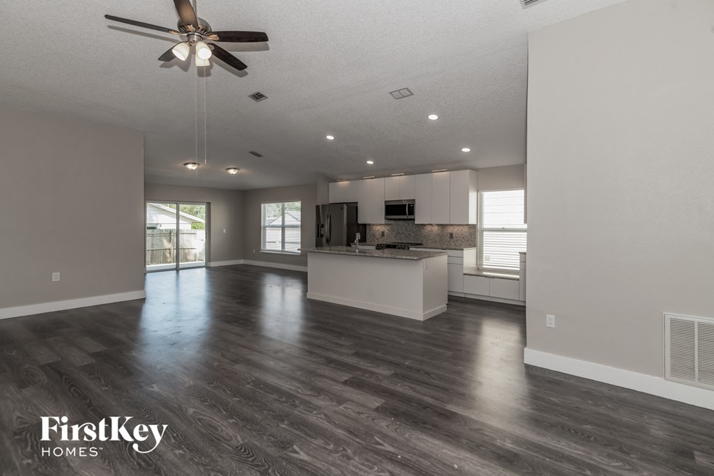 an open kitchen and living room with a ceiling fan