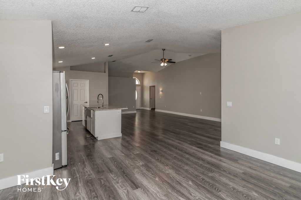 the living room and kitchen of an empty house