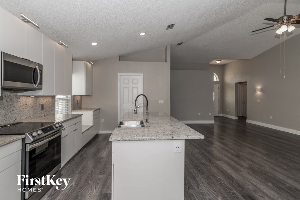 a kitchen with granite counter tops and white cabinets
