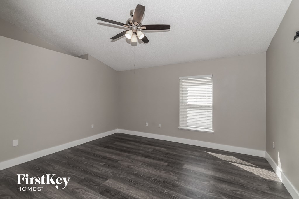 a living room with a ceiling fan and wood floors