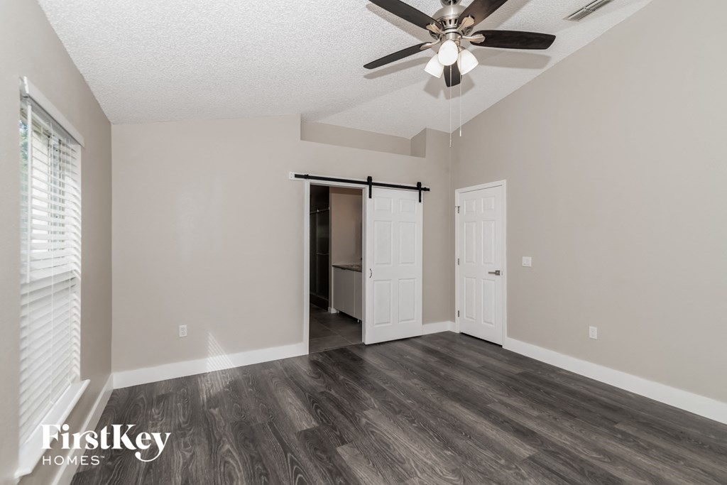 the living room of our studio apartment atrium with a ceiling fan and a closet