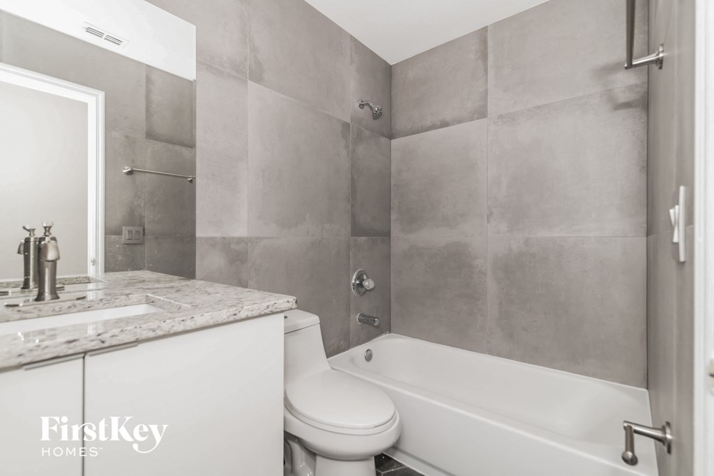 a white bathroom with a toilet and a tub and a sink