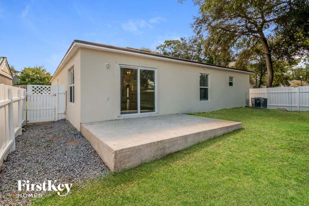 a small white house with a yard and a white fence