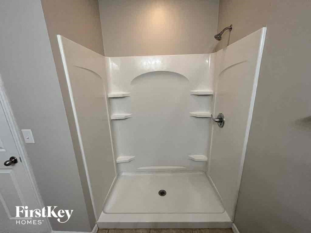 A white bathroom with a walk in shower.