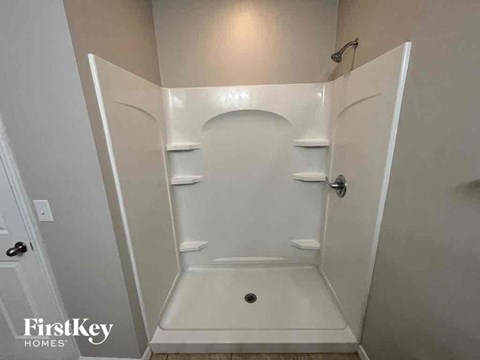 A white bathroom with a walk in shower.