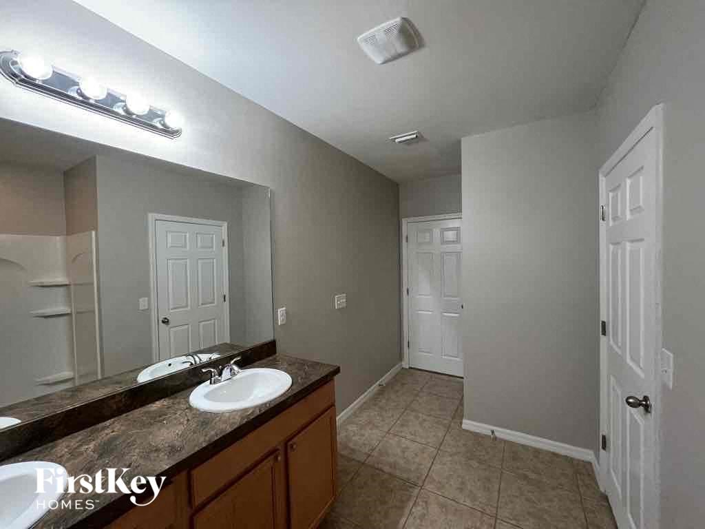 A bathroom with a double sink vanity and a mirror above it.
