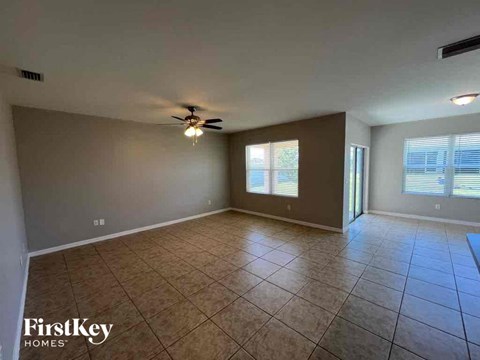 A spacious room with a ceiling fan and tiled flooring.