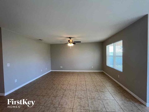 A room with a ceiling fan and tile flooring.