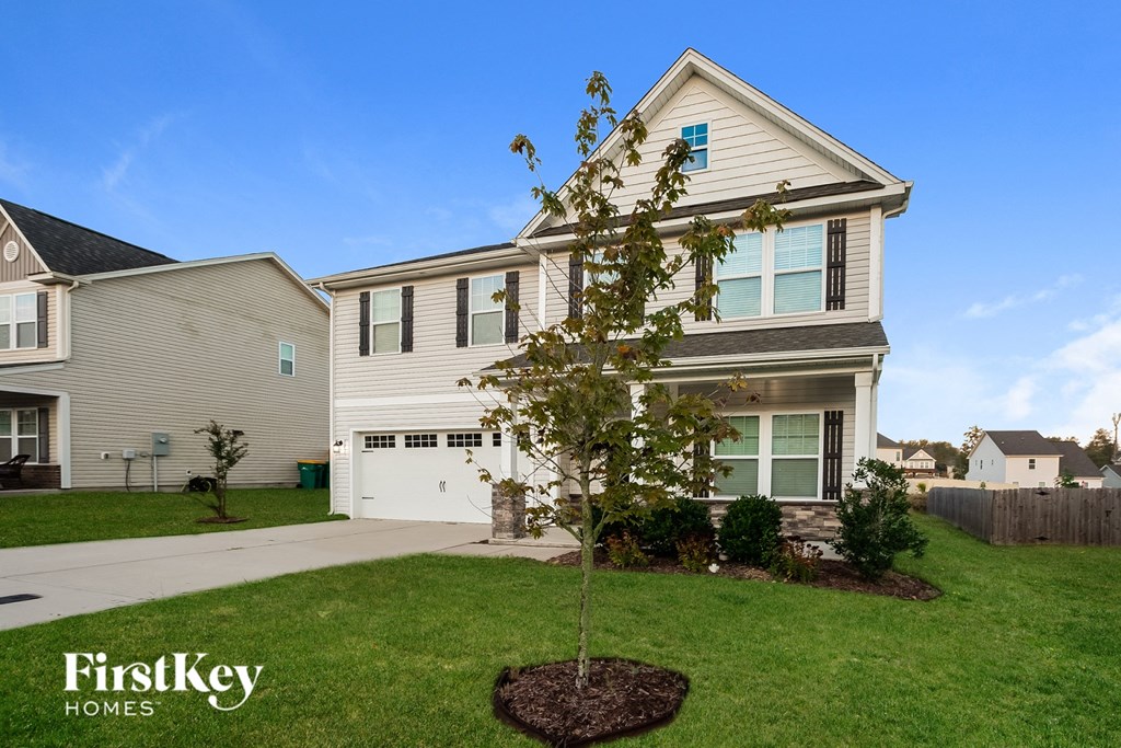 a home with a small tree in the front yard