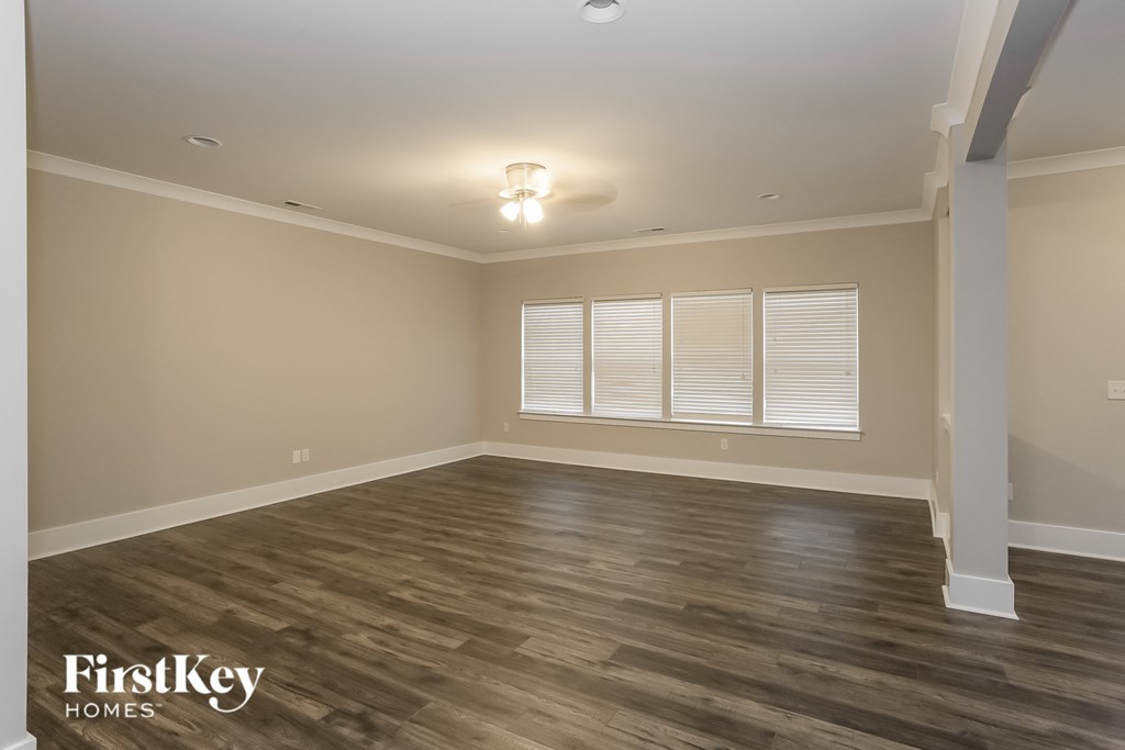 the spacious living room with hardwood flooring and a large window