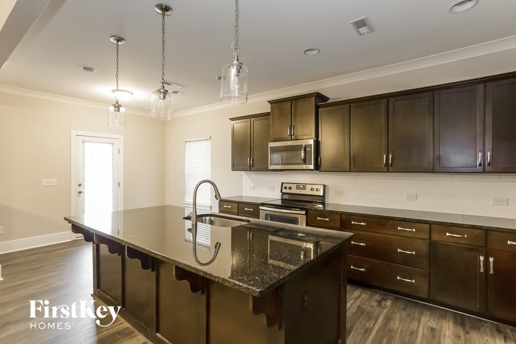 a kitchen with dark wood cabinets and granite counter tops