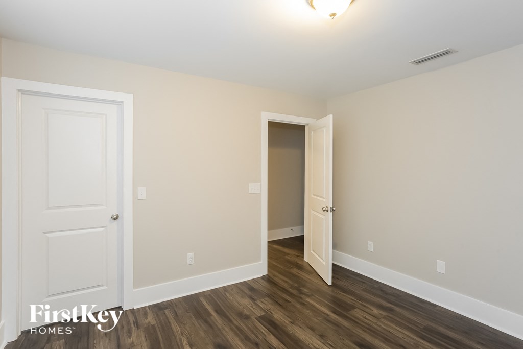 the living room of an apartment with a door to the hallway and a door closet