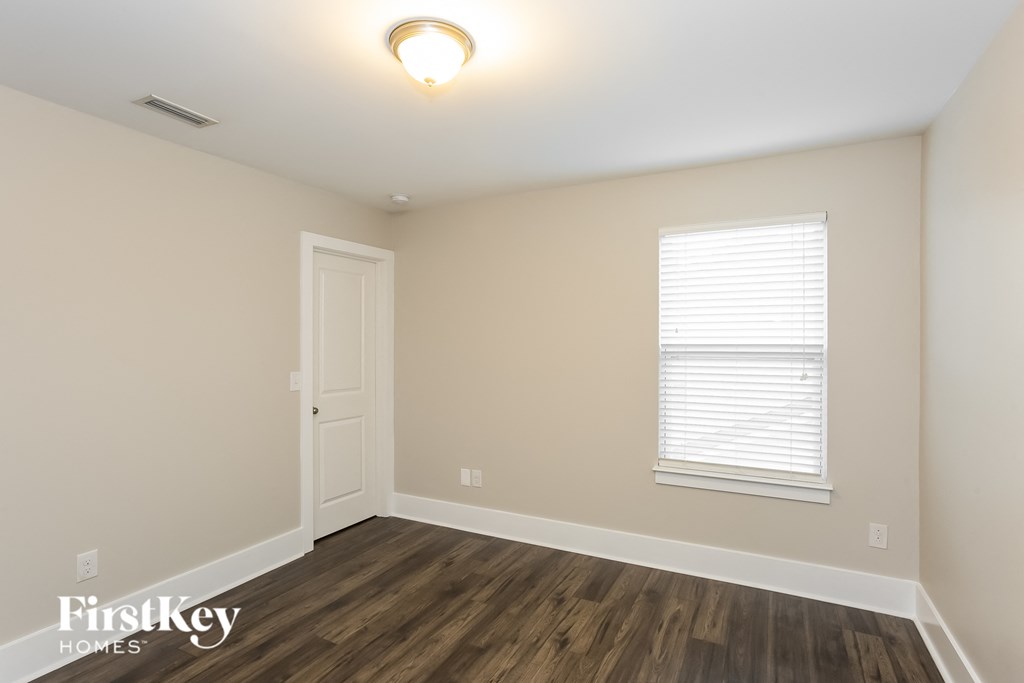 the living room of an empty house with wooden floors and a window