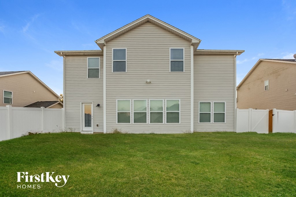 a beige house with a lawn in front of it