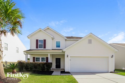 a white house with red shutters and a palm tree