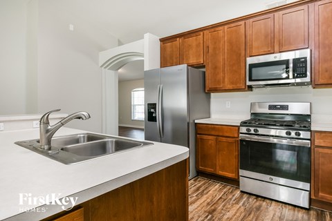 a kitchen with wooden cabinets and stainless steel appliances and a sink
