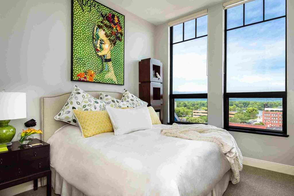 a bedroom with a bed and a painting on the wall
