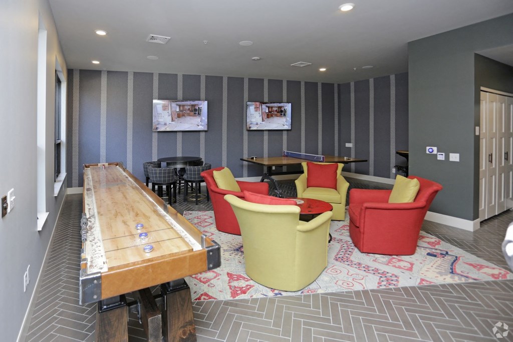 a game room with a pool table and chairs