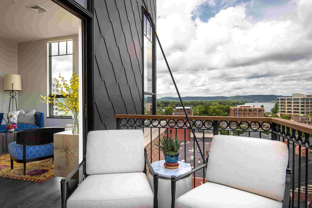 a room with a balcony and a view of the city