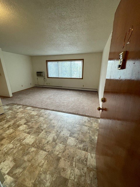 an empty living room with a door and a window
