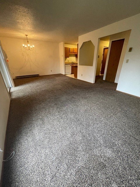 an empty living room with a carpeted floor