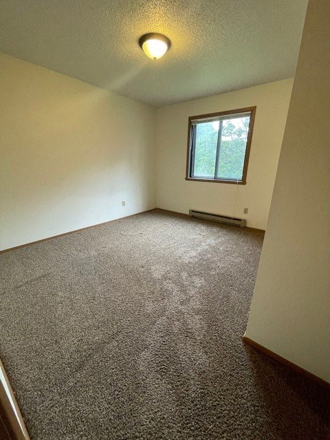 an empty room with a window and a carpet floor