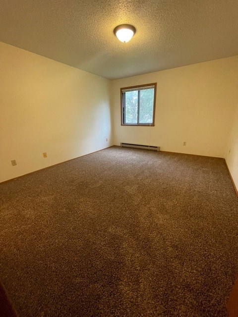 an empty room with a window and a carpet
