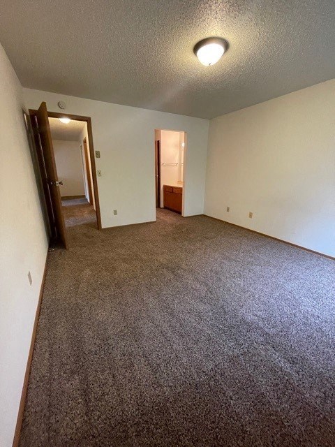 an empty room with a carpeted floor and white walls