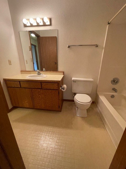 a bathroom with a toilet and a sink and a bath tub