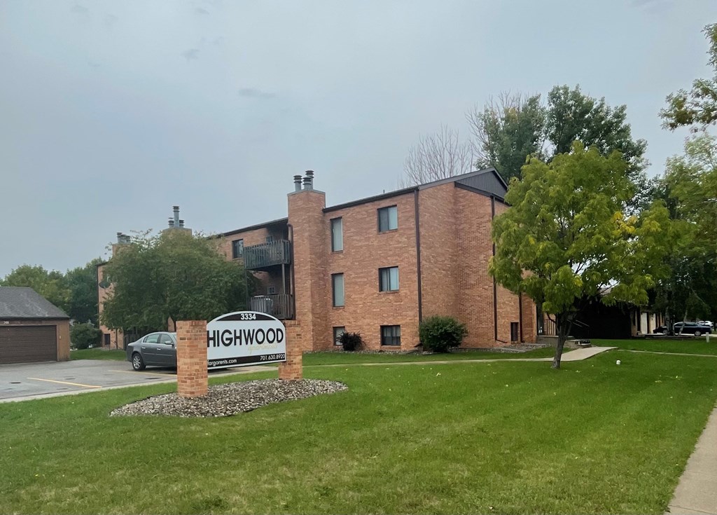 a brick building with a sign for highwood apartments