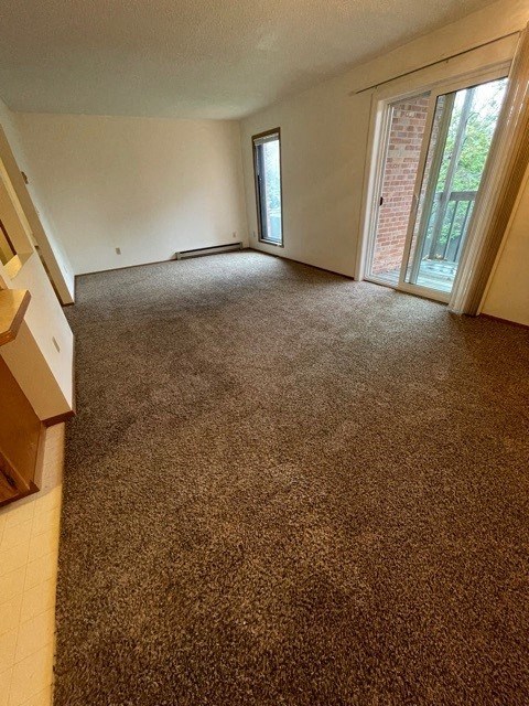 an empty room with a carpeted floor and a door