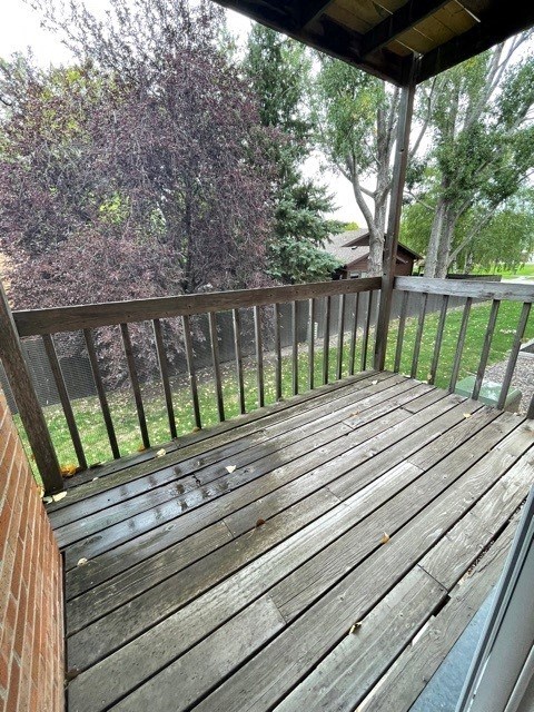 a backyard deck with a wooden fence and trees