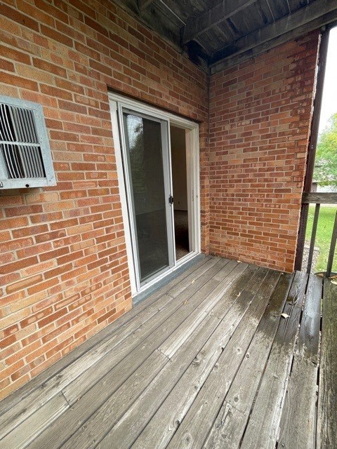a balcony with a brick wall and a sliding glass door