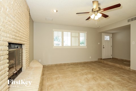 a living room with a fireplace and a ceiling fan