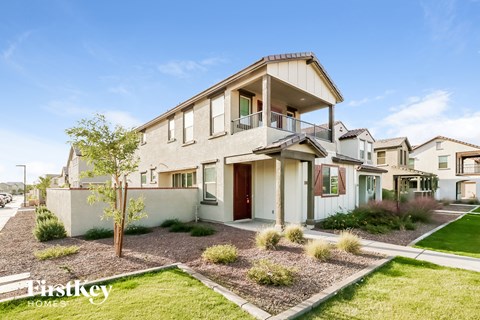 a view of a house with a balcony and a yard