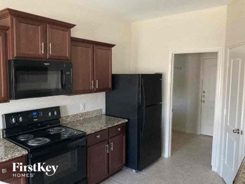 A kitchen with black appliances and wooden cabinets.
