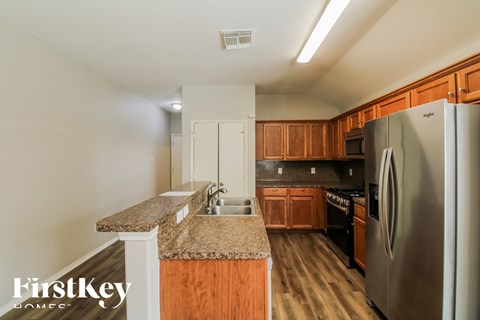 A kitchen with wooden cabinets and a granite countertop.