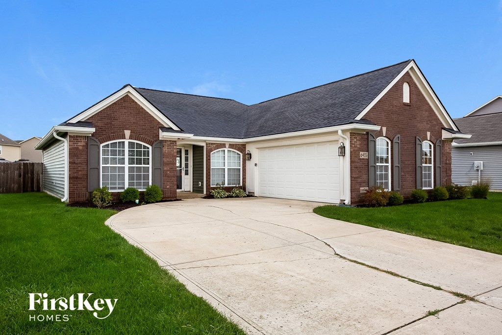 A brick house with a garage door is for sale.